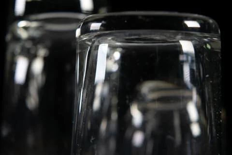 Three empty shot glasses on black background. Stock Photos
