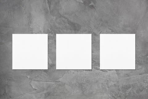 Three empty white square business card mockups on dark grey concrete backgrou Stock Photos