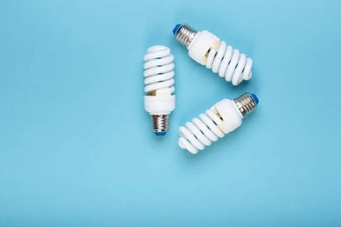 Three Energy saving lamps in the shape of a recycling symbol. Eco green energy Stock Photos