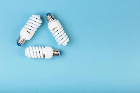 Three Energy saving lamps in the shape of a recycling symbol. Eco green energy Stock Photos