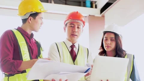 Three Engineer and Architects is brainstorming on a building blueprint in constr Stock Footage 147500285