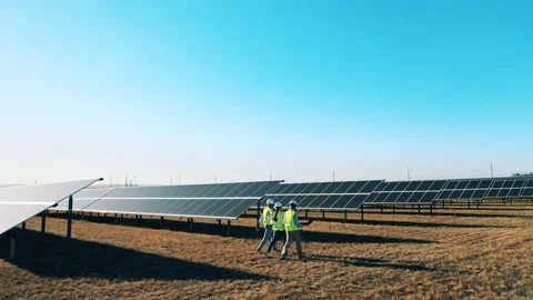 Three engineers discussing solar farm arrangement Stock Footage 142206118