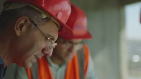 Тhree engineers  opening the blueprint of building project and discussing Vídeos de archivo 154016835