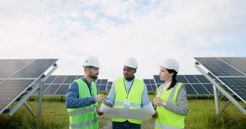 Three engineers in special uniforms with white helmets discuss work processes on Stock Footage 139508431