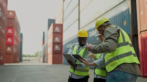 Three engineers using tablet and laptop working together at container warehouse. Stock Footage 264759624