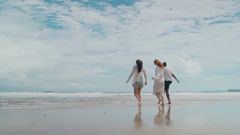 Three Ethnically Joyfully Playing by the Ocean, Experiencing Freedom and Calm Stock Footage 314063402