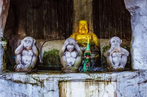Three evil monkey statues with Buddha on the background Stock Photos