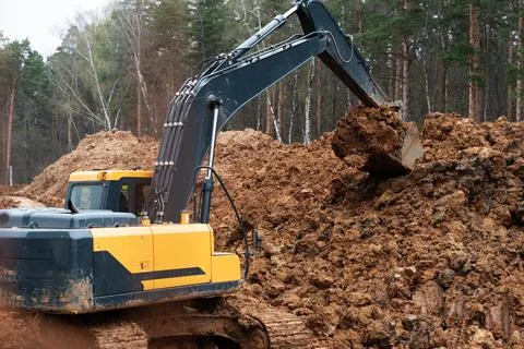 Three excavators in the process of work digs Foto stock