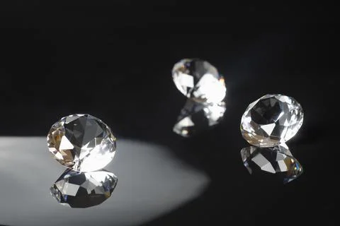 Three excellent pure diamonds with reflection on black mirror background 스톡 사진