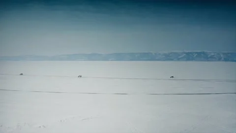 Three expedition vehicles drive in the middle of the snow-covered wasteland of Stock Footage 228826651