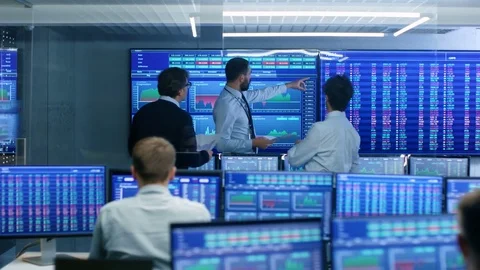 Three Experienced Stock Traders Talking Business, Consulting Documents. Stock Footage 81277711