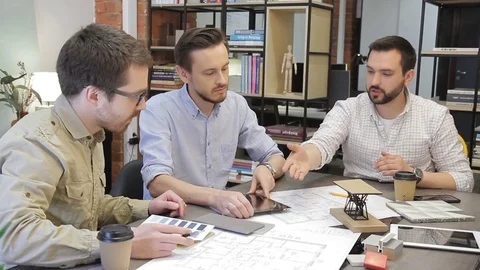 Three experts discuss business issues sitting in office, using tablets. Stock Footage 83027313