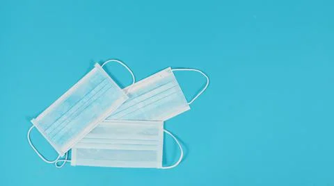Three face masks on blue background. Stock Photos