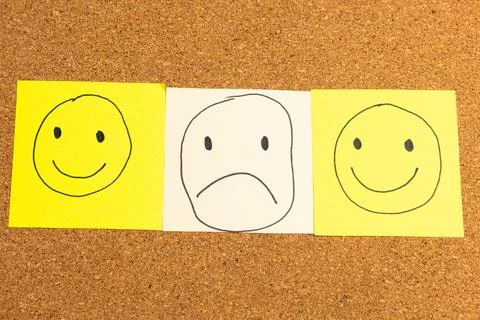 Three faces on a corkboard, one smiling, one frowning, and one blank Stock Photos