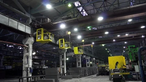 Three factory cranes in dark workshop transport graphite bars, movement steel Stock Footage 115926632