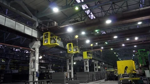 Three factory cranes in a dark workshop transport graphite bars, around the rust Stock Footage 115926734