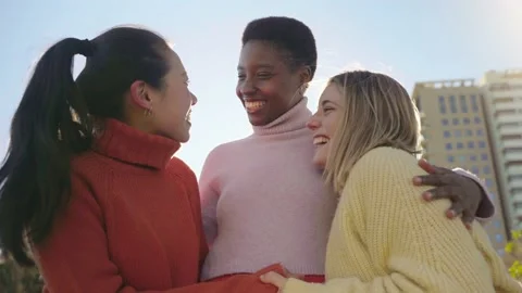 Three female friends affectionately hug each other having fun together laughing 스톡 동영상 231053403