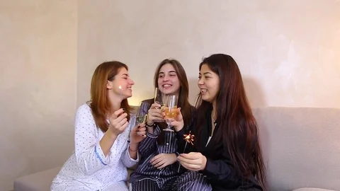 Three female friends celebrate holiday with wine cheers and bengal fire Stock Footage