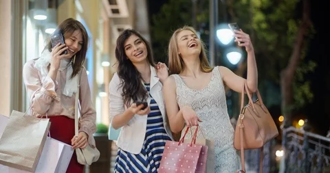 Three female friends walking down broadway near shopping centers, with shopping Stock-Footage 94528671