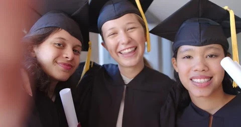 Three female grads shifting in hall, finger over edge then moving, posing for 库存影片 340655953