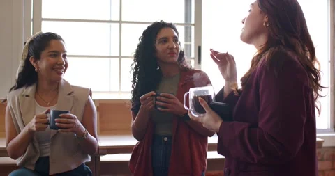Three female team chatting on break at window speaker gesturing with phone as Stock Footage 339801478