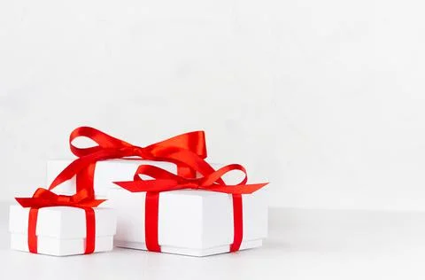 Three festive white paper boxes for gift with red silk ribbon and bow on whit Stock Photos
