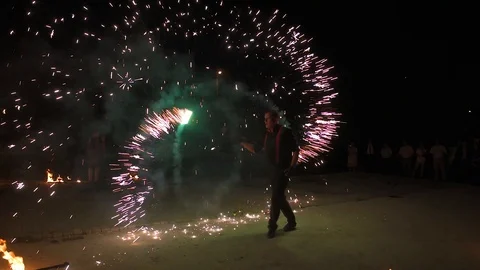 Three fire show performers standing in fire circle, performing. One juggles 動画素材 101047909