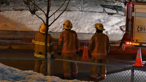 Three firefighters watching structure fire Stock Footage 105349609