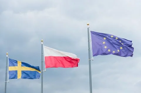 Three flags fluttering in the wind: Swedish, Polish, European Union. Stock Photos