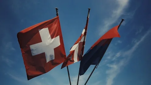 Three flags fluttering in the wind - Switzerland flag - Ticino and Lugano Stockbeeldmateriaal 123750046
