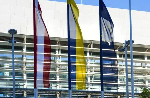 Three flags, including the Austrian and European Union flags, are displayed.. Fotos Stock