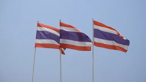 Three flags of Thailand against a blue sky flutter in the wind. Stock Footage 128659706