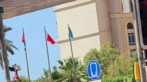 Three flags waving against a clear sky and modern building. 스톡 동영상 311591554