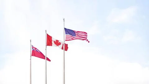 Three flags waving in the breeze against a bright sky, symbolizing unity and Stock Photos
