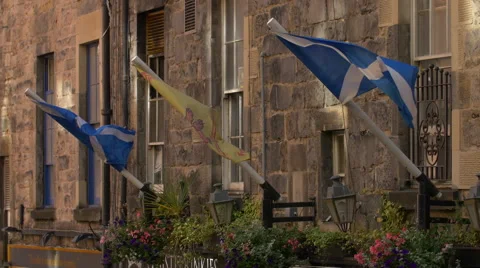 Three flags waving on a stone building in Edinburgh, UK Stock Footage 61471057