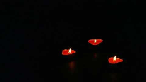 Three flames small heart candles on black background with lot of negative space Video stock 71639637