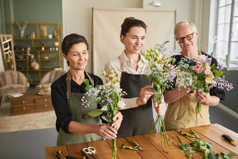Three Florists Creating Bouquets in Shop Stock Photos
