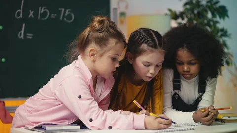 Three focused girls working on a math task together in class, finding a solution Stock Footage 303139168