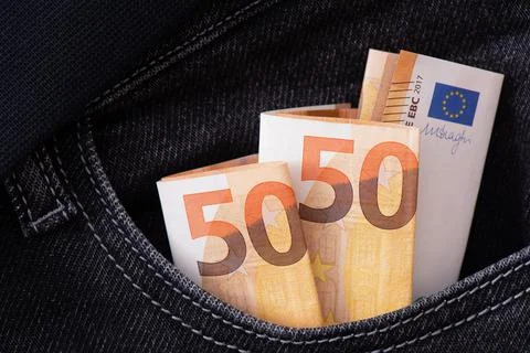 Three folded fifty euro notes protrude from the pocket of black jeans. Foto stock