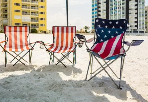 Three folding beach chairs under shade on beach Stock Photos