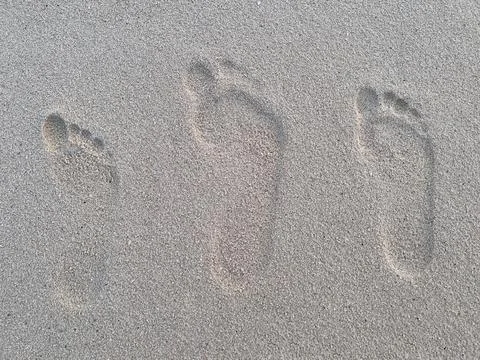 Three footprints on the sand Stock Photos