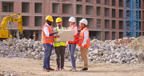 Three foremen builders and female architect standing in front of the Stock Footage 172290102