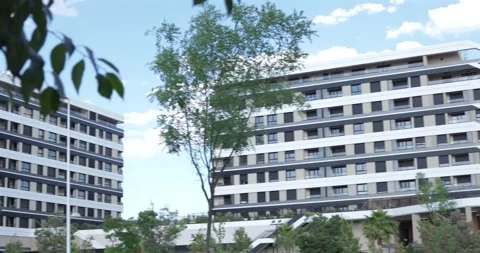 Three frames show modern apartment buildings surrounded by trees Stock Footage 336668787
