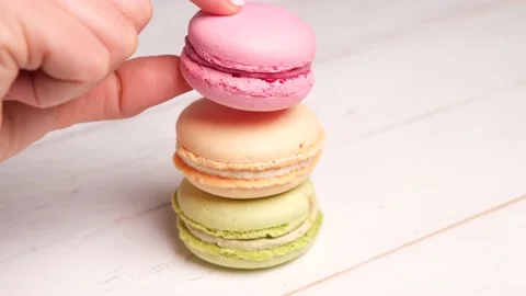 Three french macaroons on a white plate Stock Footage 154631280