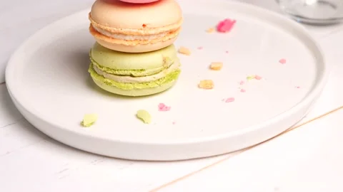 Three french macaroons on a white plate Stock Footage 155700406