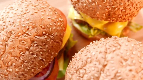Three fresh appetizing hamburgers with a salad and tomato. Closeup Stock Footage 74169327