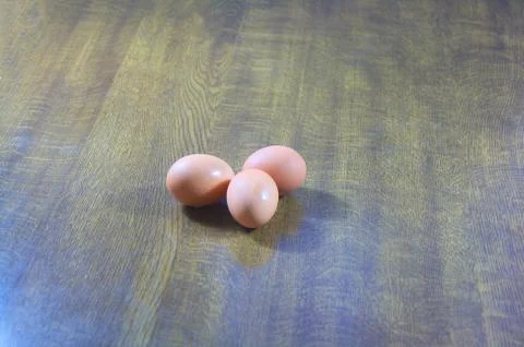 Three fresh eggs on table Stock Photos
