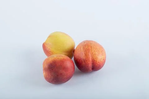 Three fresh nectarines on a white background Stock Photos