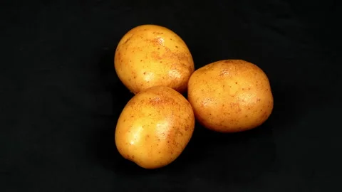 Three Fresh Raw Potatoes Rotating on Black Background Stock-Footage 343598545