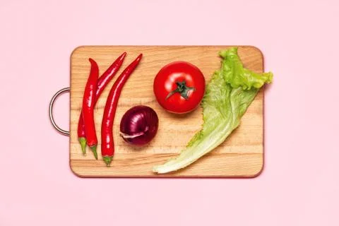 Three Fresh Red Chilli Pepper Near One Tomato, Green Lettuce And Violet Bow Stock Photos
